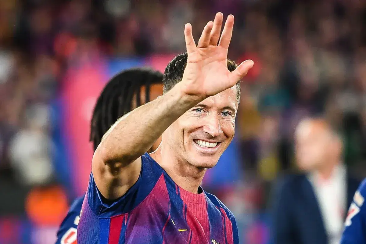 Robert Lewandowski wita kibiców, uśmiechając się szeroko. Wszyscy zastanawiają się, o co chodzi z Lewandowskim i jego nowym klubem.