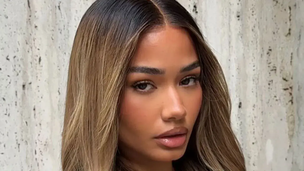 Mujer con cabello castaño oscuro con mechas rubias, un estilo que inspira cómo aclarar el pelo para un look radiante.