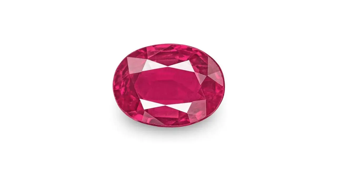 Un rubí, una **piedra preciosa roja** de intenso color, brilla con facetas que capturan la luz.