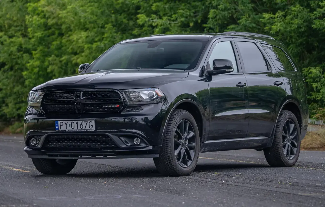 Czarny Dodge Durango 3.6, lśniący na tle zieleni, gotowy na każdą podróż.