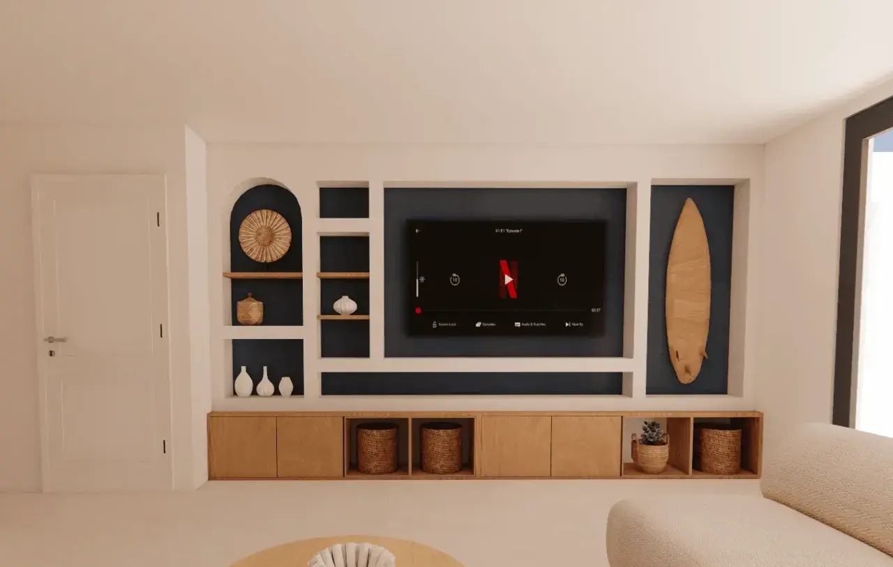 Un salon moderne avec une niche murale pour la TV, des étagères décorées et un meuble bas en bois.