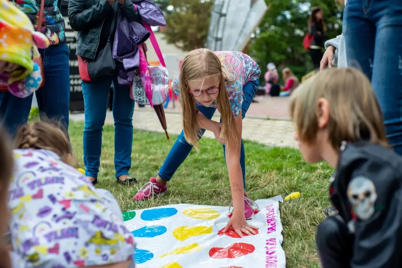 Bambini si divertono con giochi per feste di compleanno 11 anni, giocando a Twister sull'erba.