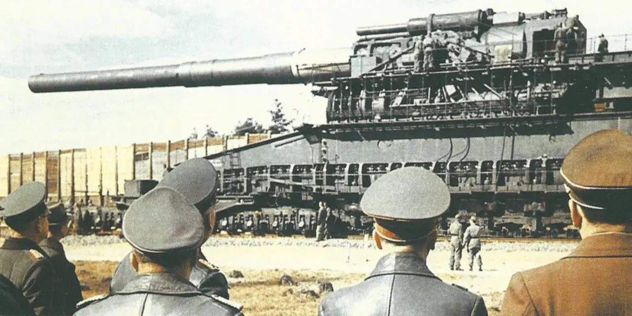 Männer in Uniformen betrachten die riesige Eisenbahngeschütz "Gustav Panzer".