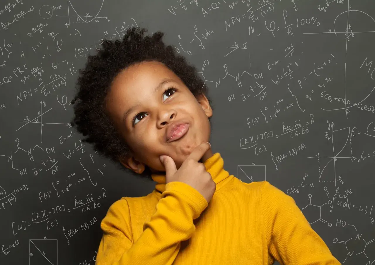 Un niño pensativo con un suéter amarillo, rodeado de fórmulas matemáticas y químicas en una pizarra, como si estuviera en el colegio.