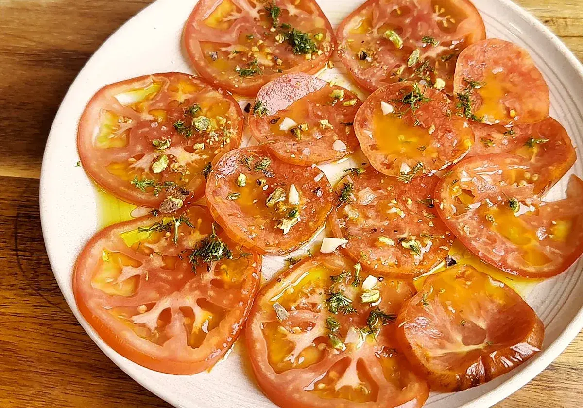 Carpaccio de tomate fresco con aceite de oliva, ajo picado y hierbas aromáticas. Un plato ligero y lleno de sabor.