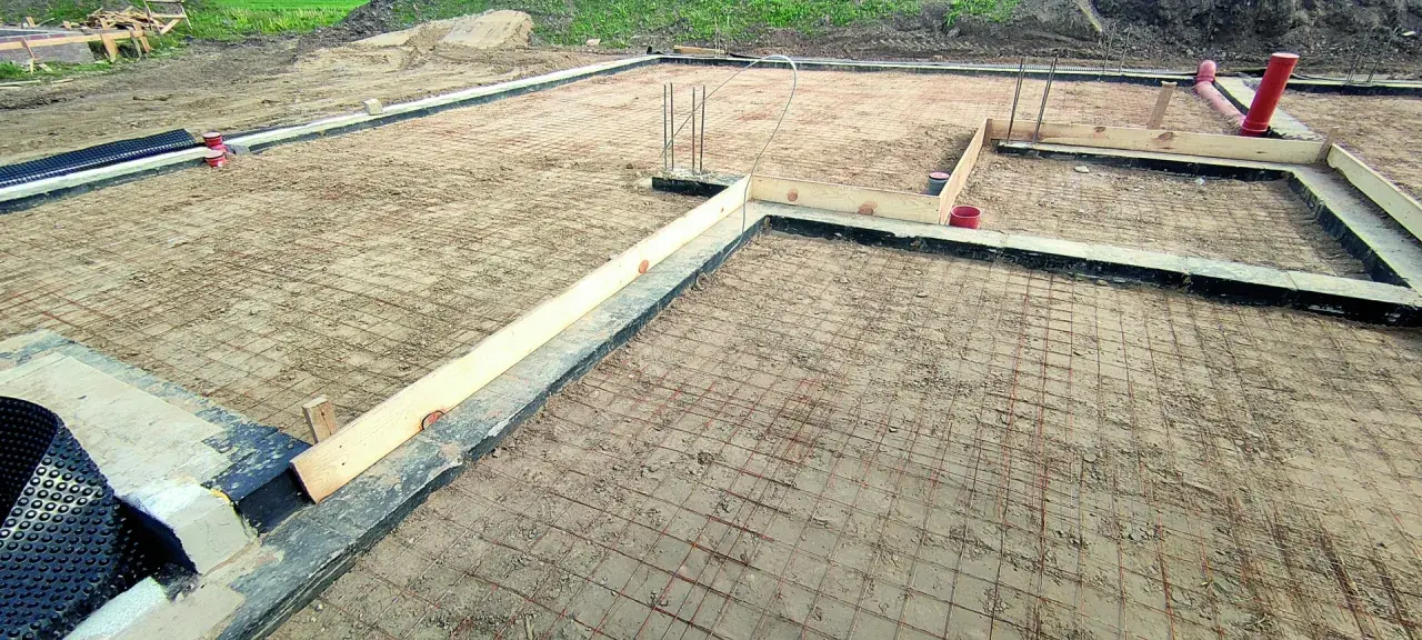 Fundament pod budowę domu, zbrojenie gotowe do zalania betonem. Chudziak ile cm grubości? Trudno ocenić bez miarki, ale wygląda solidnie.