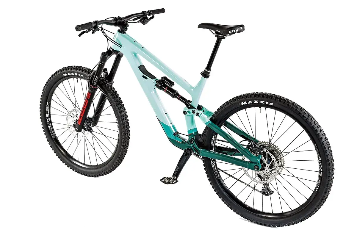 A teal and green full-suspension mountain bike, possibly a Salsa Cassidy, with Maxxis tires and a WTB saddle, ready for any trail.