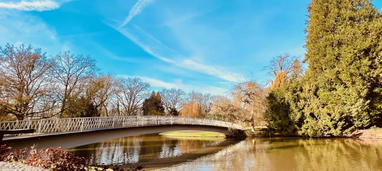 Eine Brücke über einen Teich im Bergpark Wilhelmshöhe. Hier kann man in Kassel spazieren gehen und die Natur genießen.