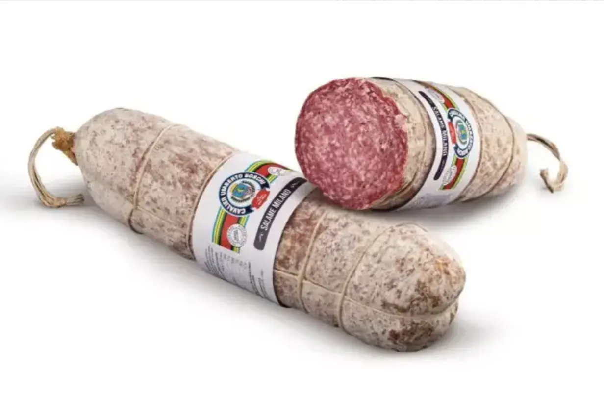 Dwa kawałki włoskiej kiełbasy, jeden przekrojony, ukazujący skąd pochodzi salami.