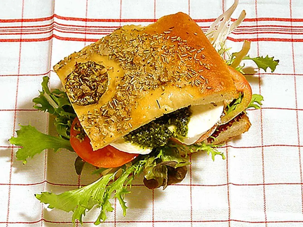 En härlig pesto macka med focaccia, mozzarella, tomat och grönsallad. Perfekt för en snabb och god lunch.