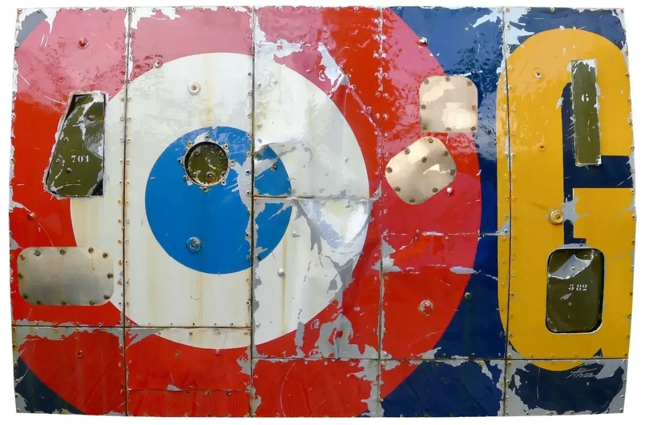 Panneau métallique style pop art, aux couleurs vives et écaillées, rappelant les cocardes d'avions et des chiffres.