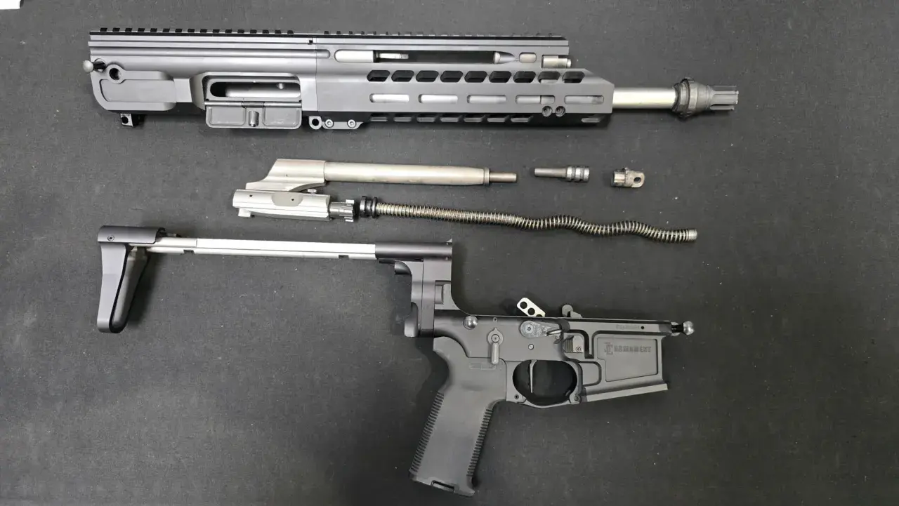 Rozłożony karabinek AR-15: górna i dolna część komory zamkowej, lufa, suwadło, sprężyna powrotna i inne części.