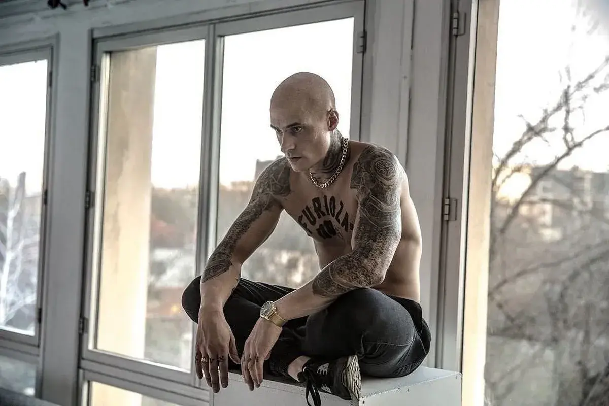 Mateusz Damięcki w filmach często wciela się w role z charakterem. Tutaj w stylizacji z tatuażami i złotym łańcuchem.