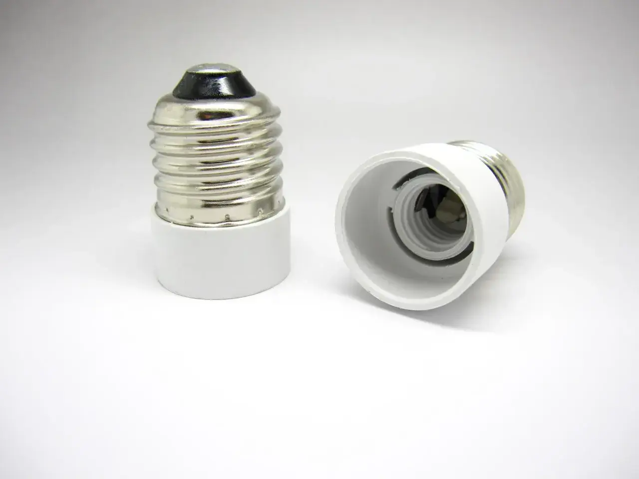 Dos adaptadores de portalámparas, uno vertical y otro horizontal, listos para convertir un casquillo E27 a E14.