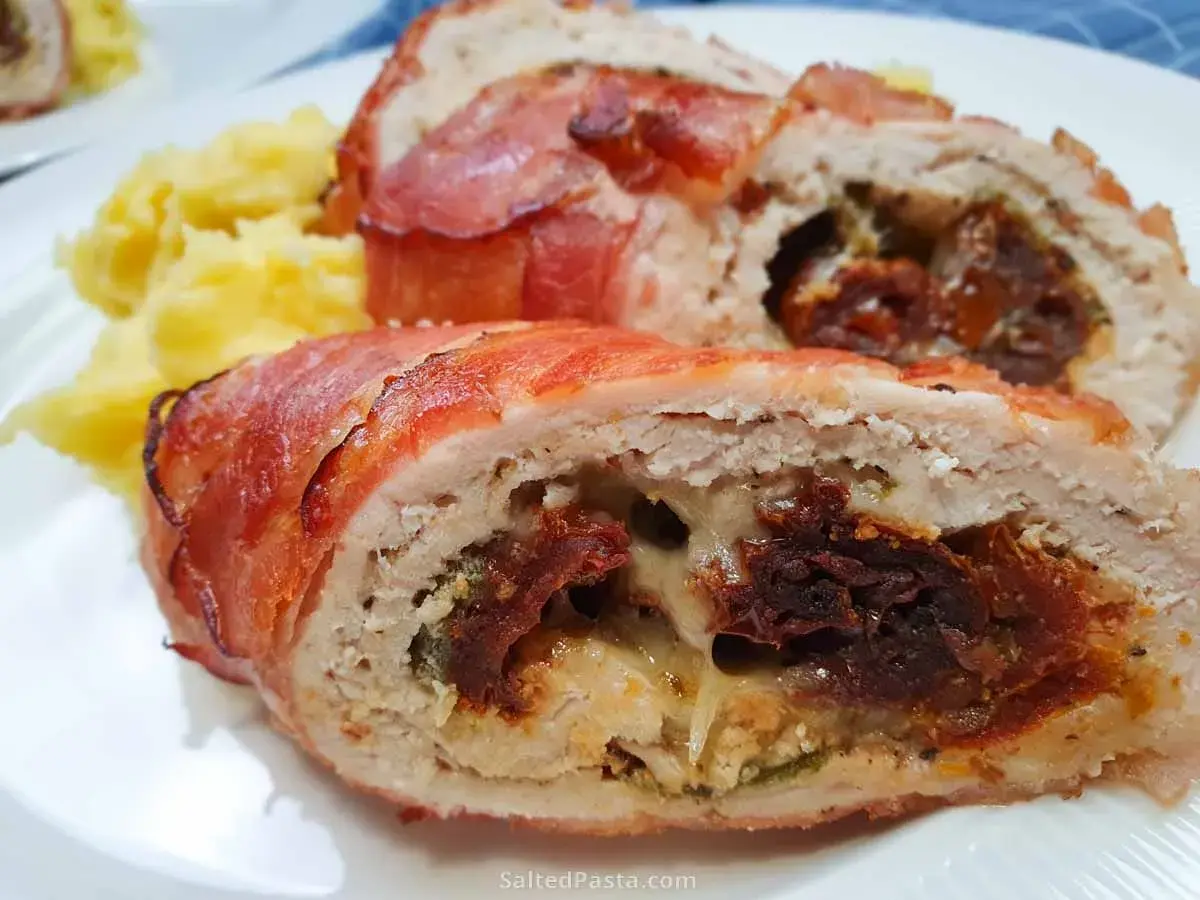 Soczysta pierś z kurczaka zawijana w boczku z serem, nadziewana suszonymi pomidorami i ziołami, podana z puree ziemniaczanym.