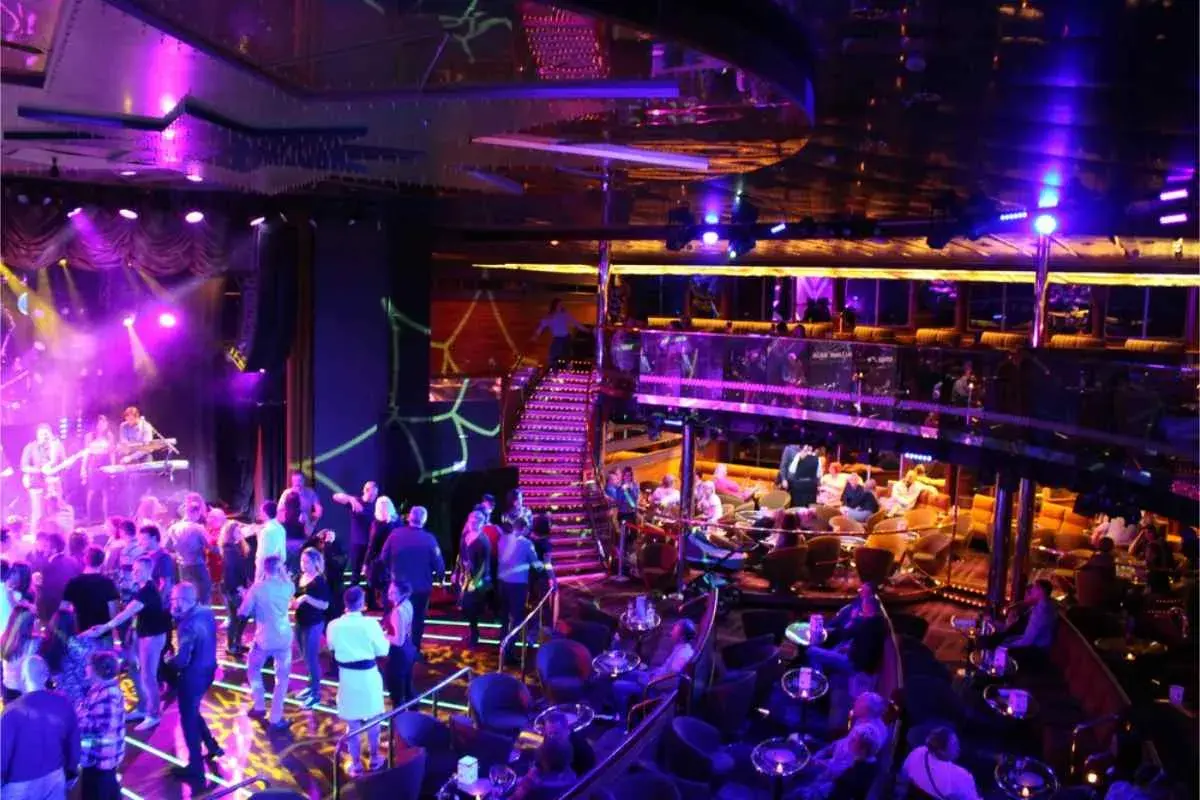 En livlig scen med ett band som spelar, folk som dansar och sitter vid bord. En trappa leder upp till en annan nivå. En typisk bild av stockholm nightlife.