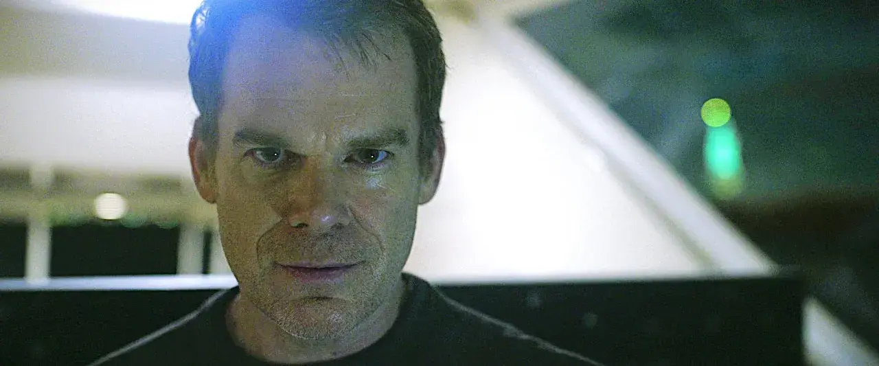 Primo piano di Dexter, con uno sguardo intenso. Le recensioni su Dexter lo descrivono come un personaggio complesso.
