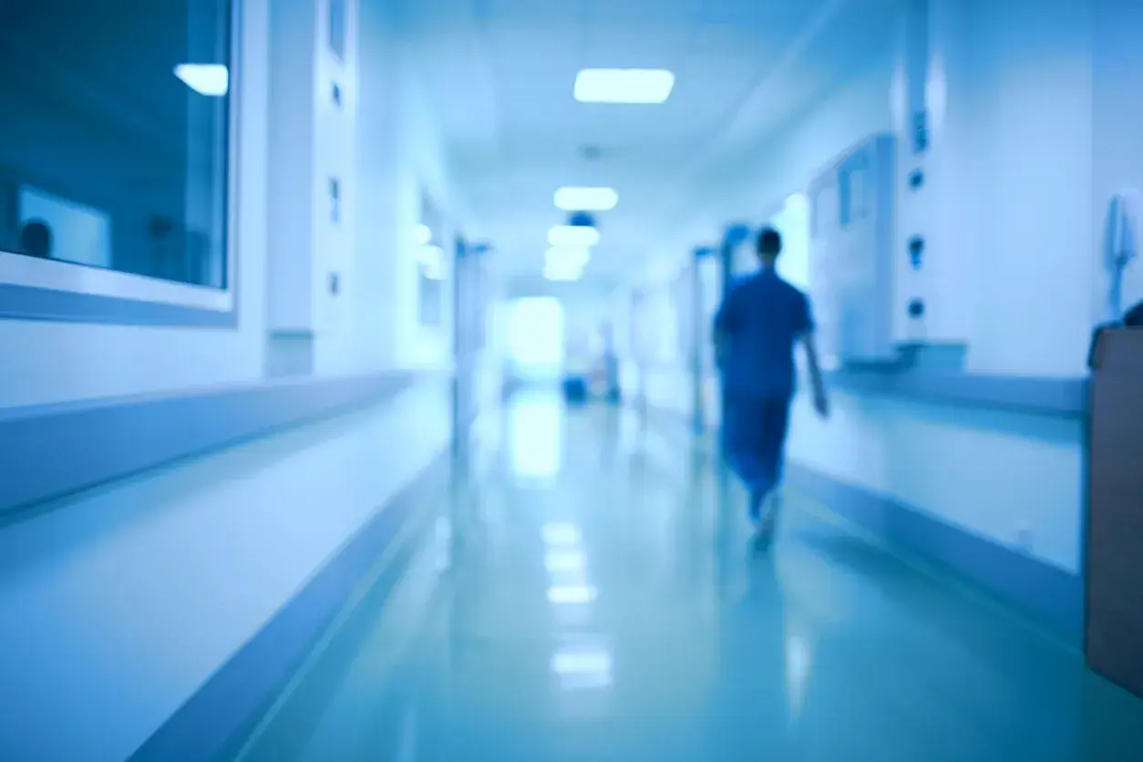 Un medico ospedaliero cammina in un corridoio. Chissà quanto prende di pensione dopo anni di servizio.