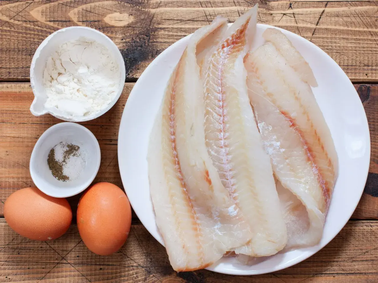 Świeże filety rybne, jajka, mąka i przyprawy gotowe do przygotowania pysznego ceviche.