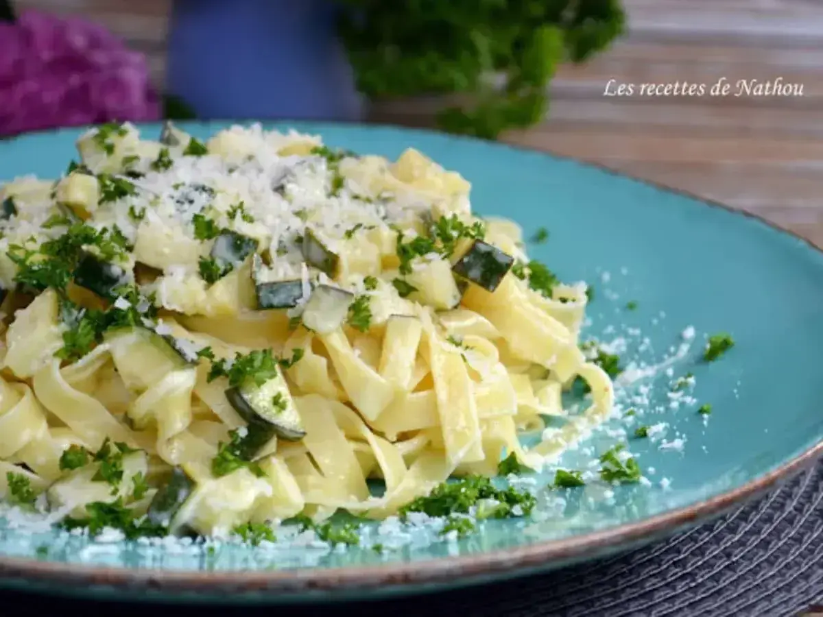 Assiette de tagliatelle de courgette crémeuse, parsemée de persil frais et de parmesan râpé. Un délice léger et savoureux.