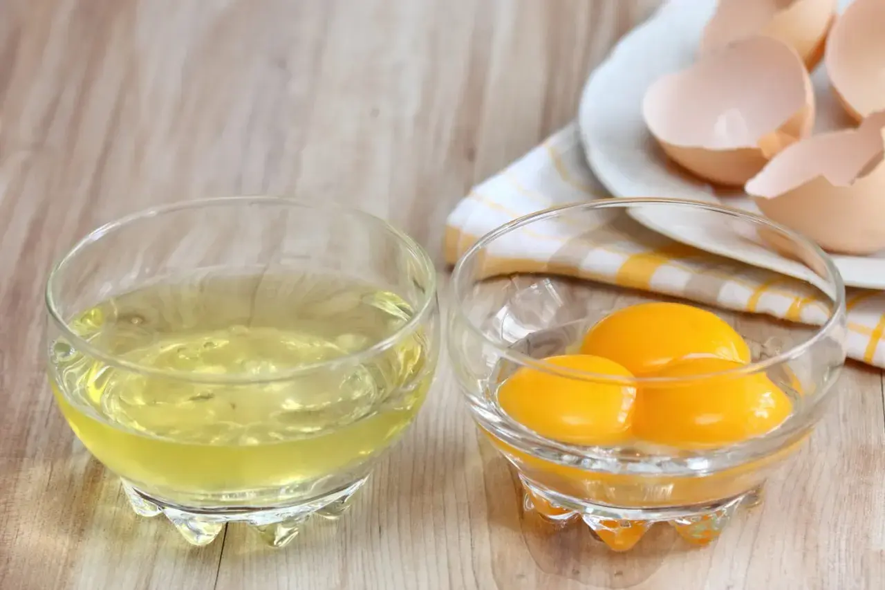 Deux bols en verre : l'un avec des blancs d'œufs, l'autre avec trois jaunes. Idéal pour tester le temps de cuisson des blancs en neige au micro-ondes.
