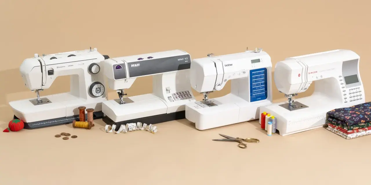 A sewing professional's dream: four white sewing machines from Husqvarna, Pfaff, Brother, and Singer, with spools of thread, fabric, and scissors.
