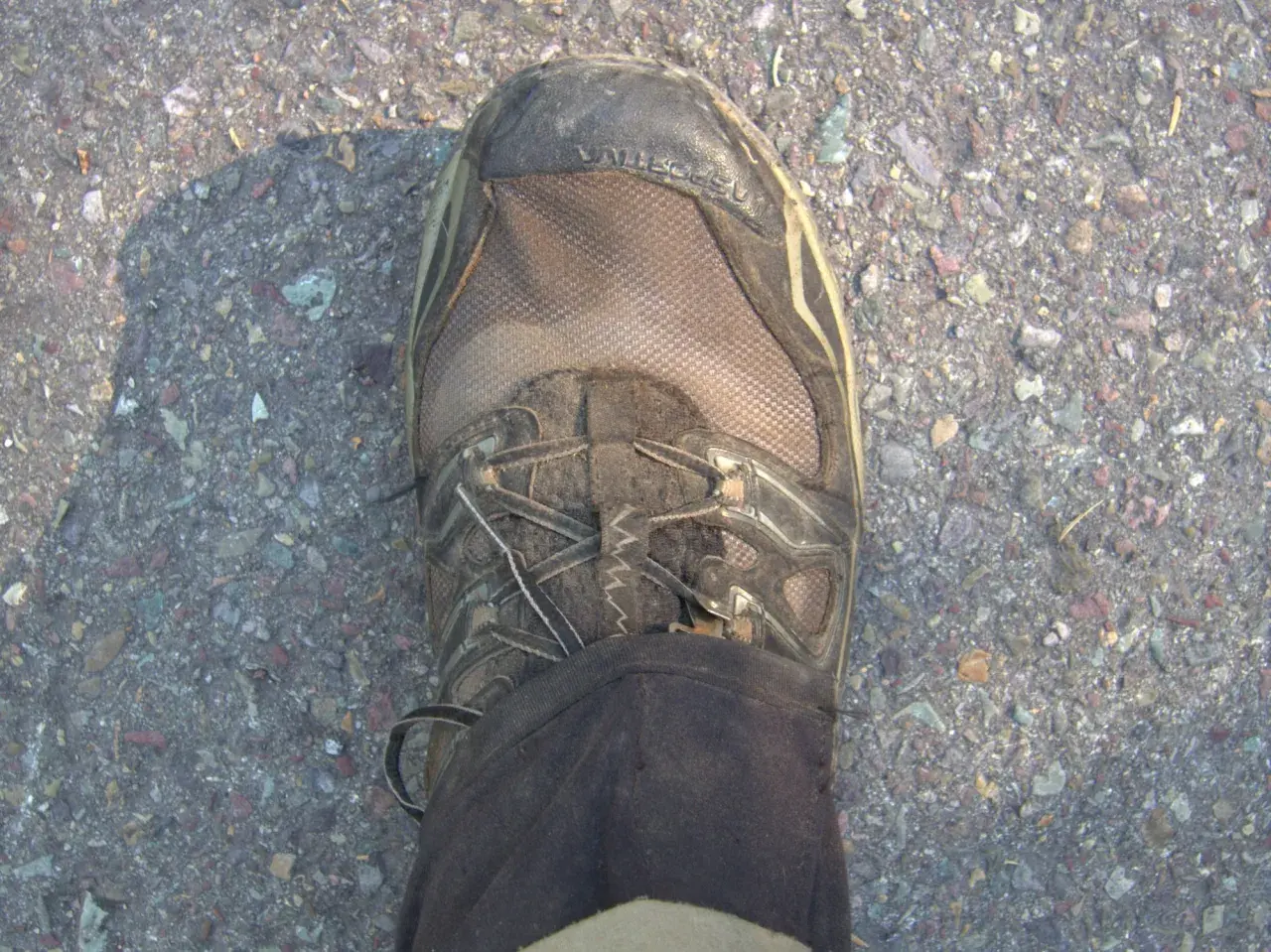 Dirty Gore-Tex hiking boot on gravel. Learn how to clean Gore-Tex shoes to keep them waterproof and ready for your next adventure.