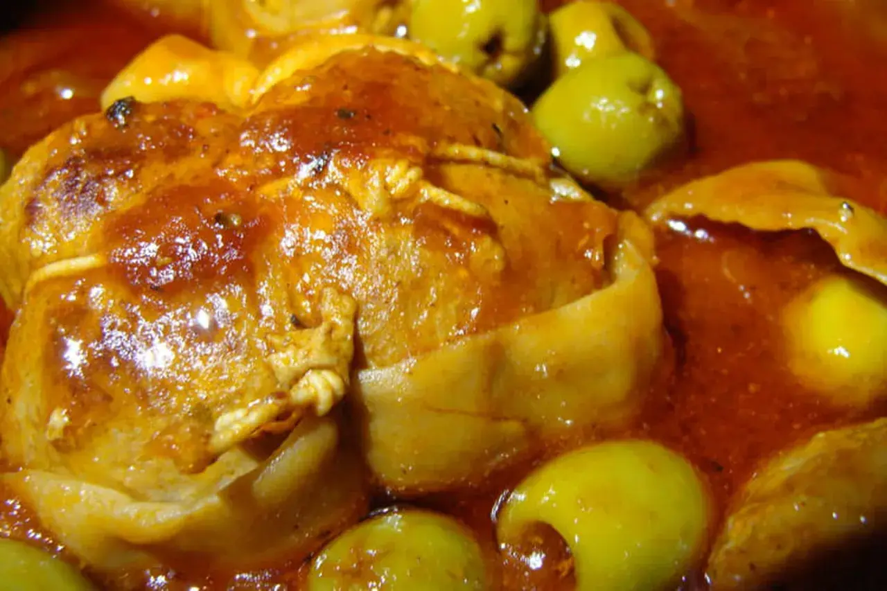 Paupiettes de veau en sauce, baignant dans un jus savoureux avec des olives vertes. La cuisson mijotée promet un plat tendre et parfumé.