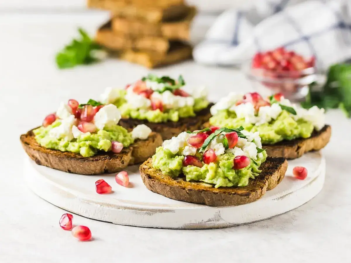 Tosty z guacamole, serem feta i granatem – idealne z czym jeść guacamole na śniadanie lub przekąskę.