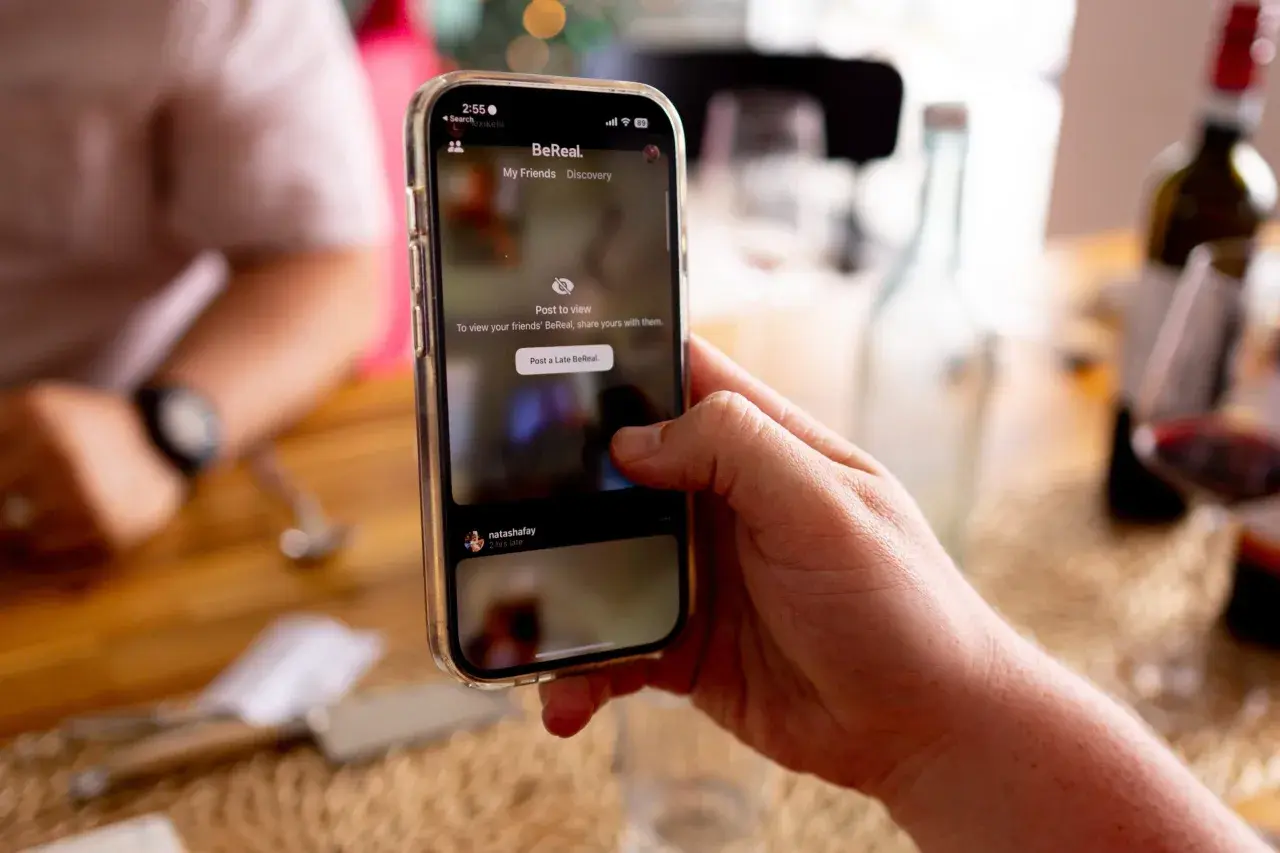 Dłoń trzyma telefon z aplikacją BeReal. To platforma, która zachęca do dzielenia się autentycznymi chwilami.
