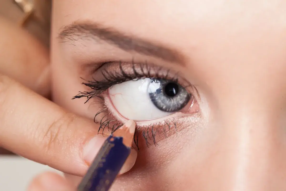 Aplicando delineador en la linea de agua del ojo, creando un look intenso.