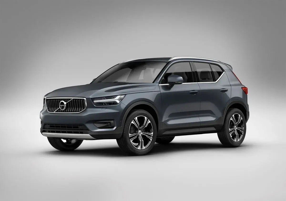 Elegancki, ciemnoszary Volvo XC40 prezentuje się na tle jasnej ściany, gotowy na miejskie wyzwania.