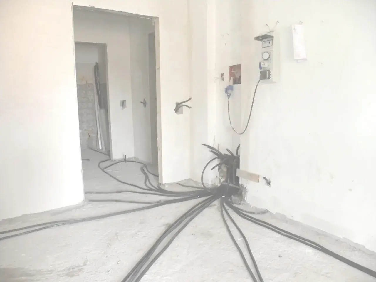 Rifacimento impianto elettrico in corso. Cavi neri si diramano dal muro, pronti per la manutenzione ordinaria o straordinaria.