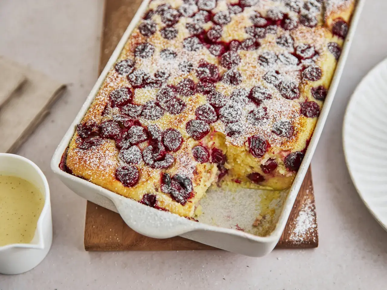 Ein goldbrauner Grießauflauf mit Kirschen, bestäubt mit Puderzucker. Dieses Grießauflauf Rezept sieht köstlich aus!