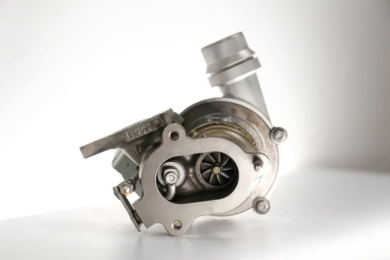Metalowa turbosprężarka z widocznymi łopatkami wirnika. To serce każdego silnika, które dzięki technologii turbo compound zwiększa moc.