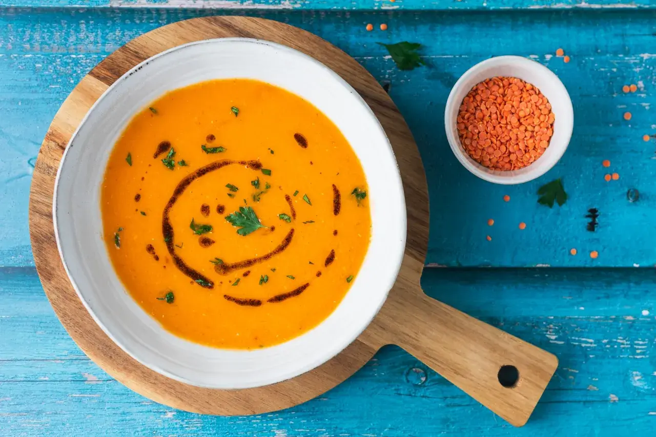 Ciorba turca ricetta originale: zuppa di lenticchie rosse cremosa, guarnita con prezzemolo e olio.
