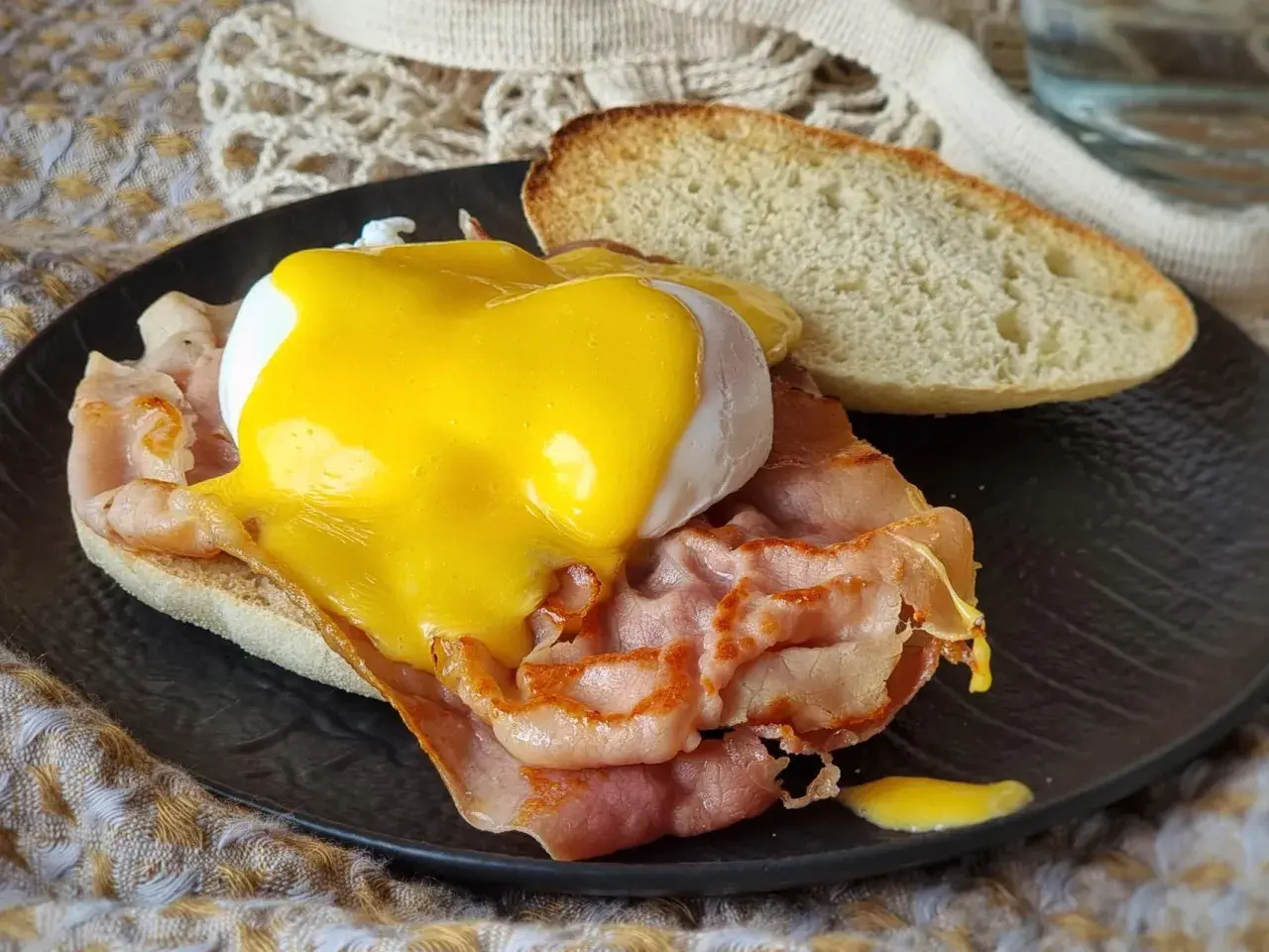 Deliciosos huevos benedictinos con jamón, huevo escalfado y salsa holandesa sobre pan tostado. Un clásico desayuno.