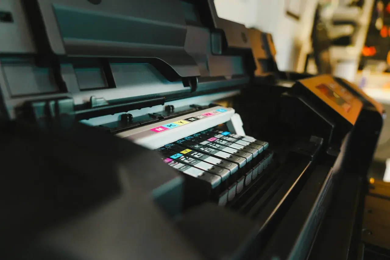 Wnętrze plotera z kolorowymi tuszami (CMYK). Zastanawiasz się, ploter co to? To urządzenie do drukowania wielkoformatowych wydruków.