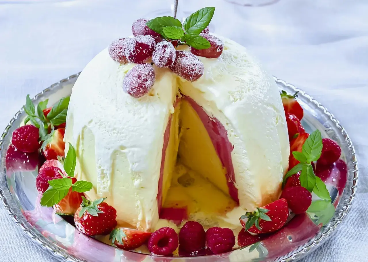 En magnifik elle nyårsdessert, en kupol av glass med lager av frukt och bär, dekorerad med färska jordgubbar och hallon.