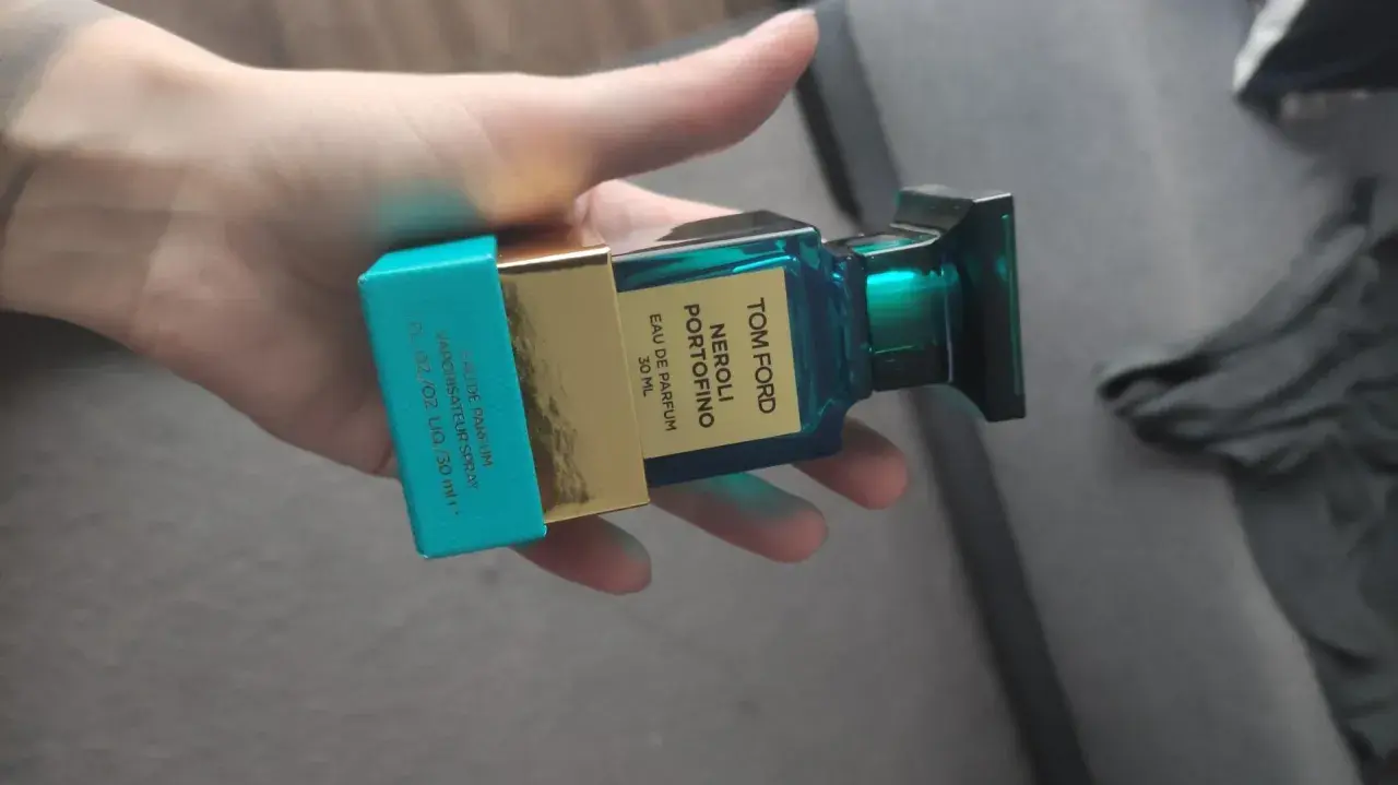 Dłoń trzyma buteleczkę perfum Tom Ford Neroli Portofino.