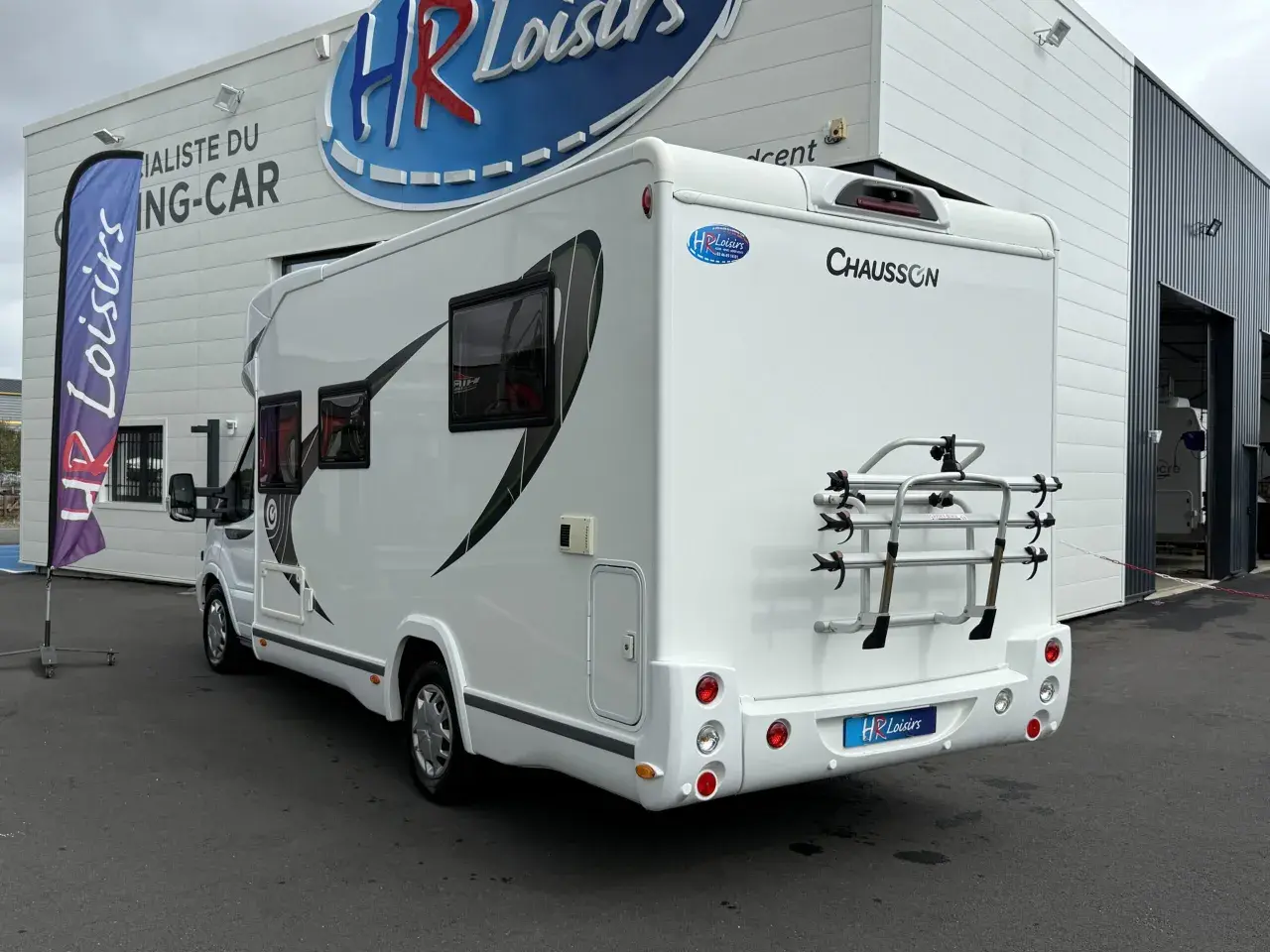 Camping-car Chausson 628 EB blanc, vu de l'arrière, avec porte-vélos. Idéal pour un avis camping-car.