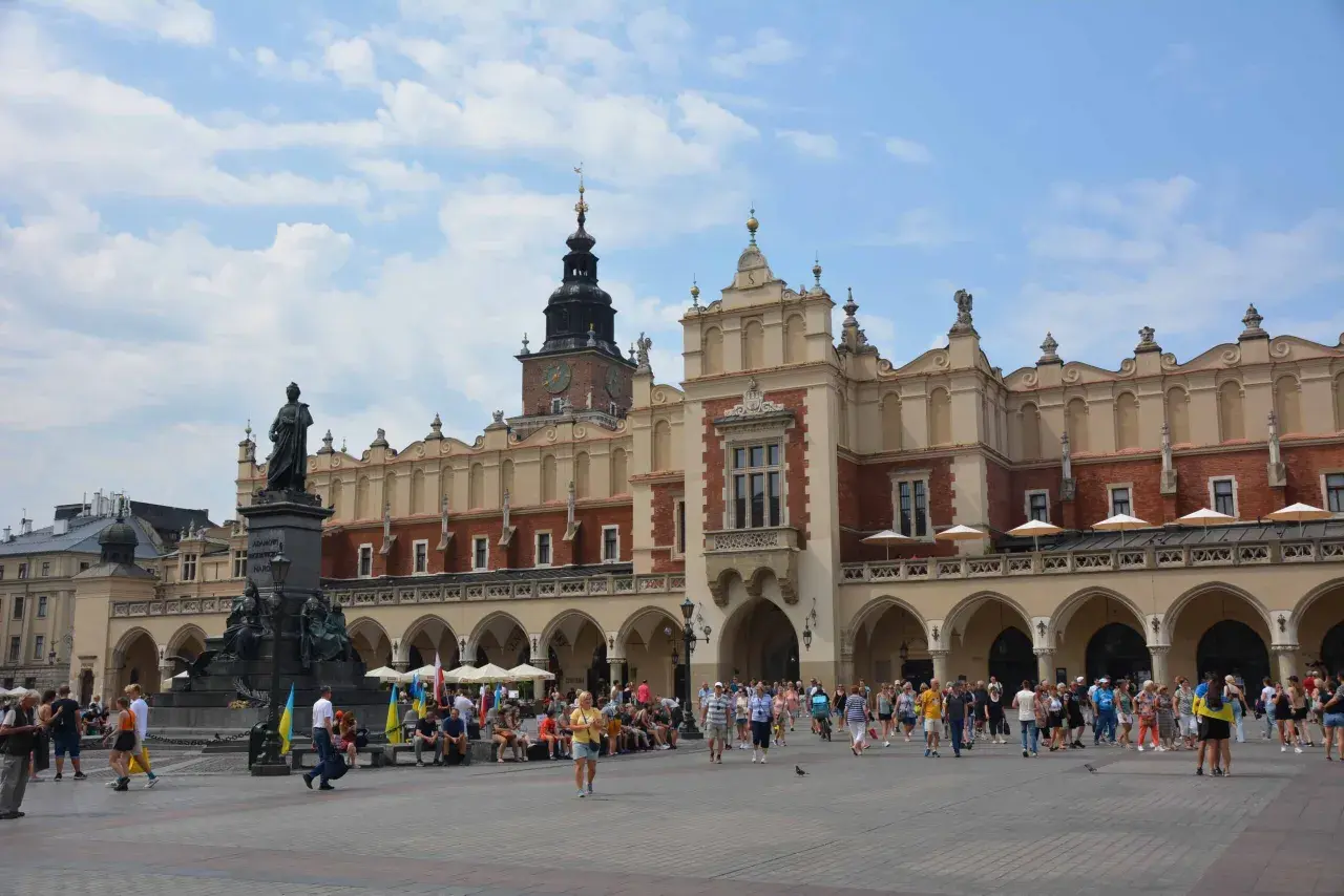 Der Marktplatz in Krakau, ein lebendiges Zentrum nach einer Reise von Breslau. Menschen flanieren vor der historischen Tuchhallen-Architektur.
