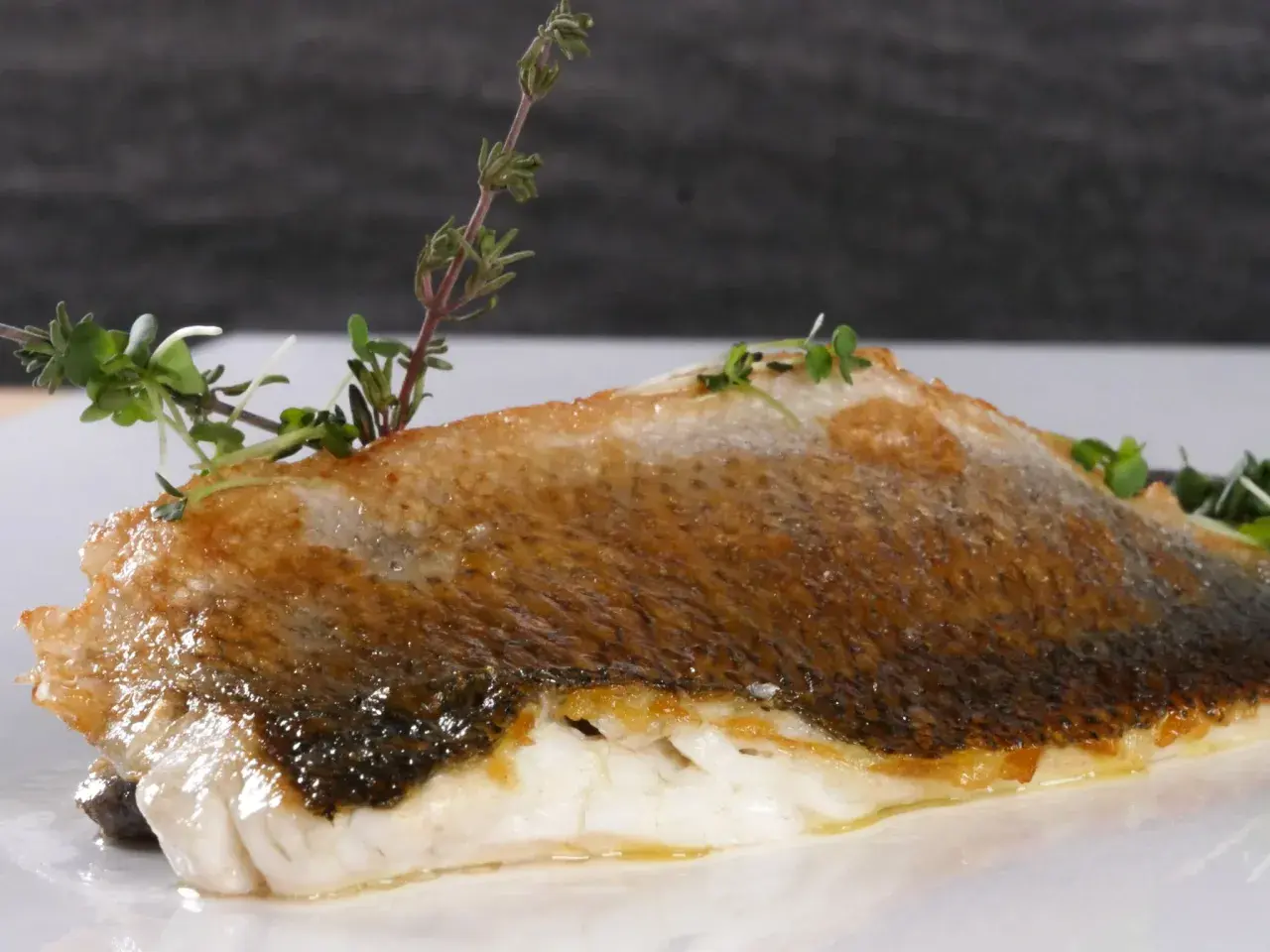 Perfekt gegrillter Wolfsbarsch mit knuspriger Haut und frischen Kräutern, ein Genuss für alle Sinne.
