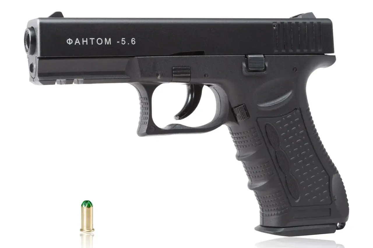 Czarny pistolet hukowy 6mm z Czech, model "ФАНТОМ -5.6", obok naboju.