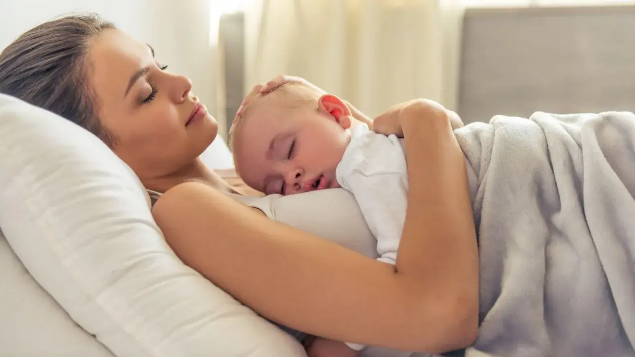 Mama i dziecko śpią wtuleni w siebie. To piękny moment kangurowania, pełen miłości i spokoju.