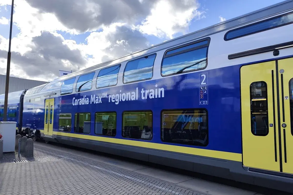 Niebiesko-żółty dwupoziomowy wagon kolejowy Coradia Max™ regional train stoi na peronie.