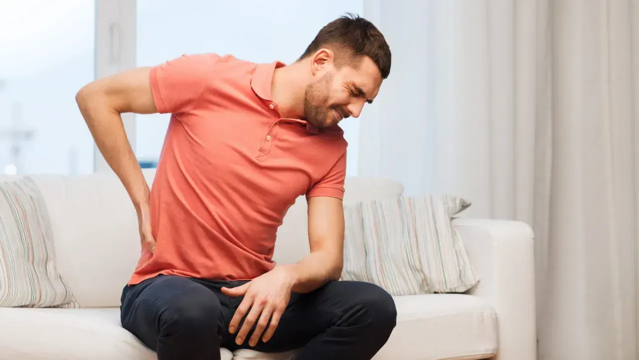 Mann mit Rückenschmerzen sucht nach hallux schmerzen lindern hausmittel.