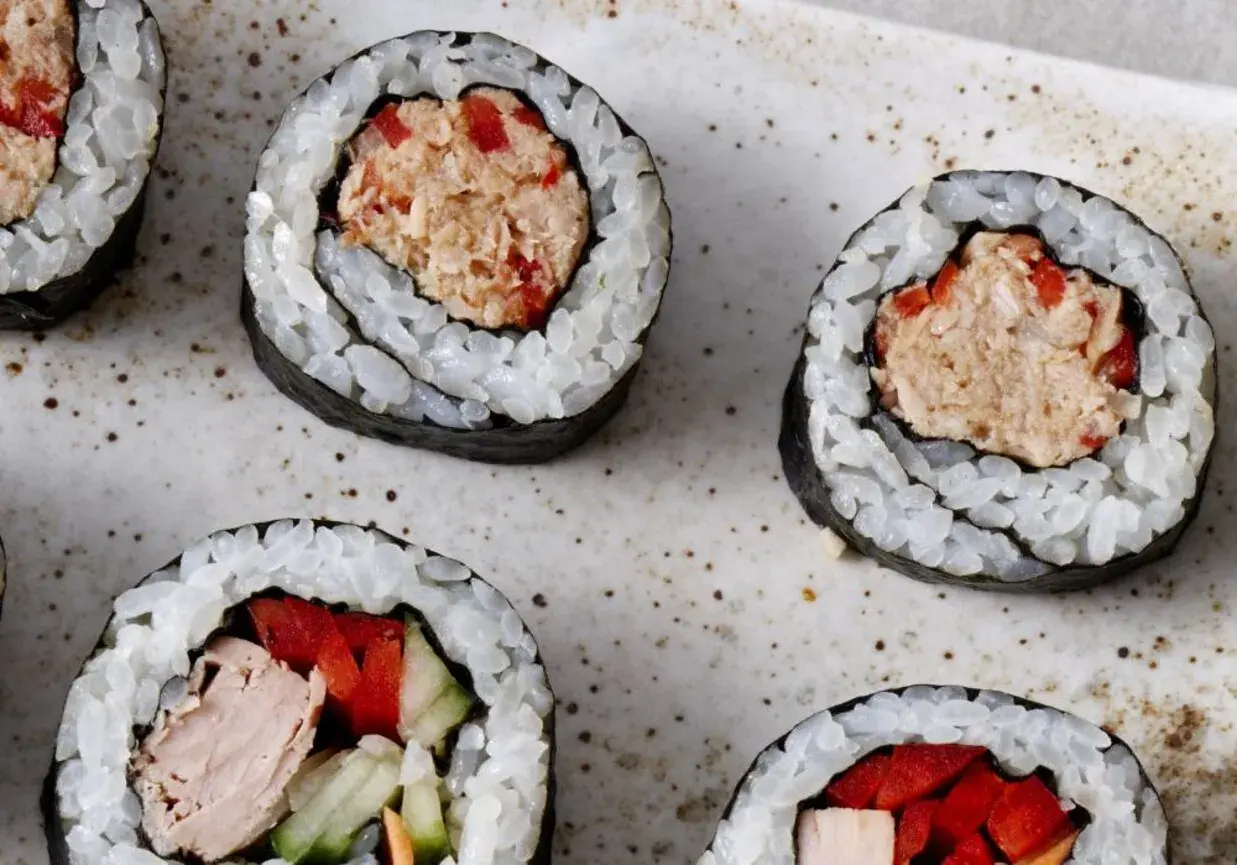 Roladki sushi z ryżem i nori, wypełnione rozdrobnionym tuńczykiem w sosie własnym, papryką i ogórkiem.