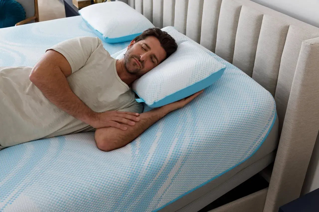 Man sleeping peacefully on a Tempur-Pedic pillow, enjoying the comfort and subtle, fresh tempurpedic pillow smell.