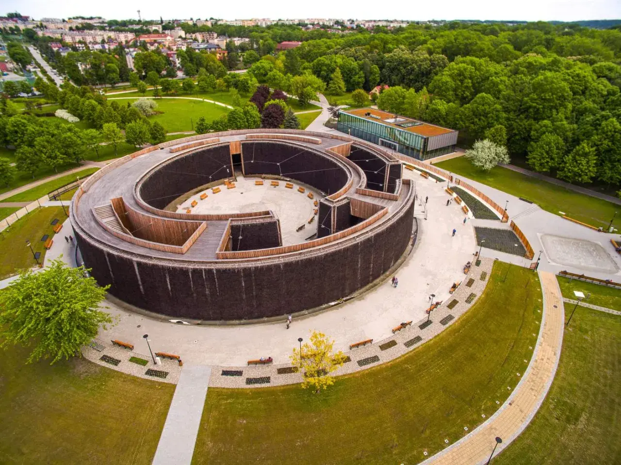 Nowoczesne termy w Busku-Zdroju, spiralna tężnia z drewnianymi elementami i otaczający ją park.